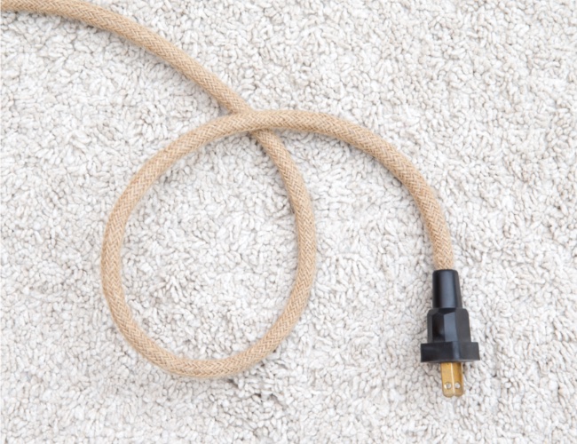 Cords under rugs can be a fire hazard - Custom Electrical can help!