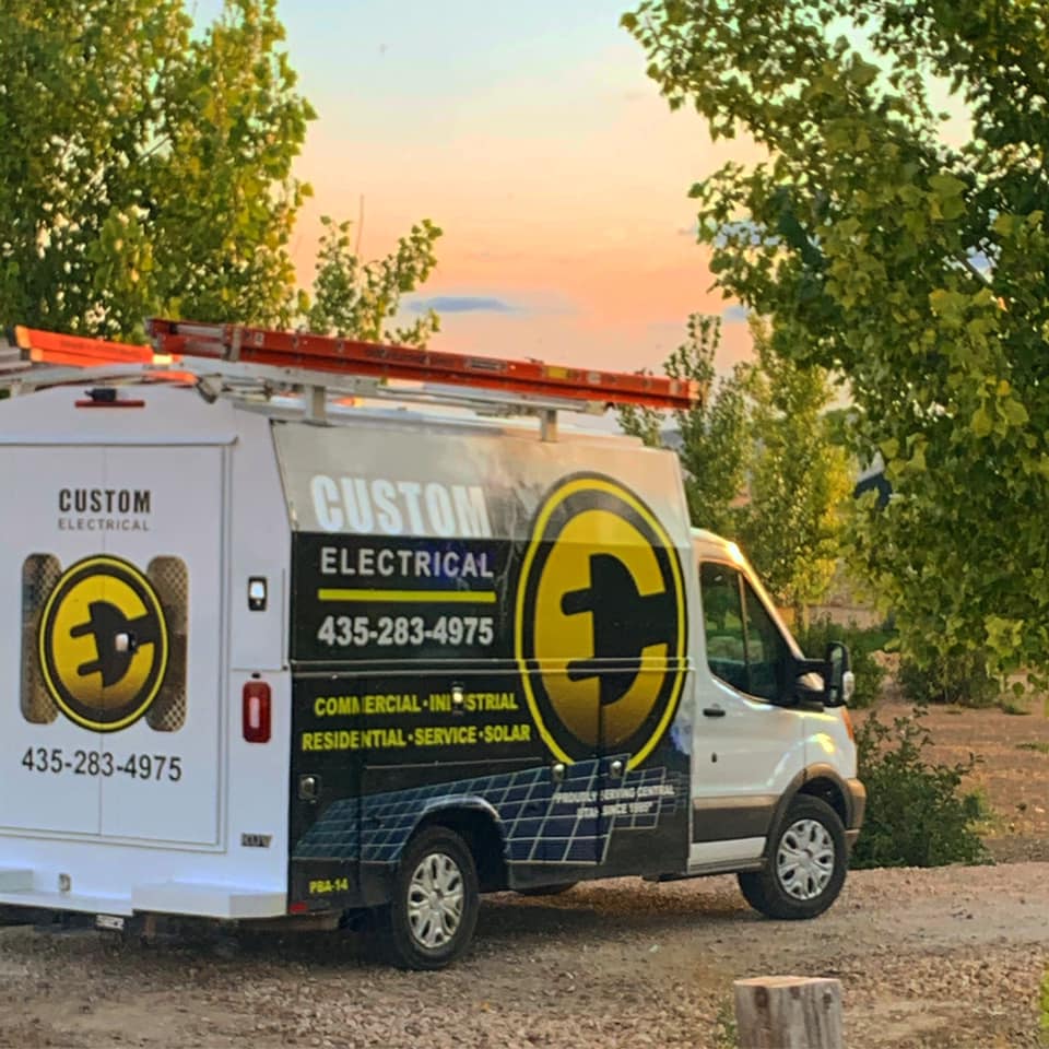 Custom Electrical van parked in Utah's beautiful mountains overlooking an amber sunset.