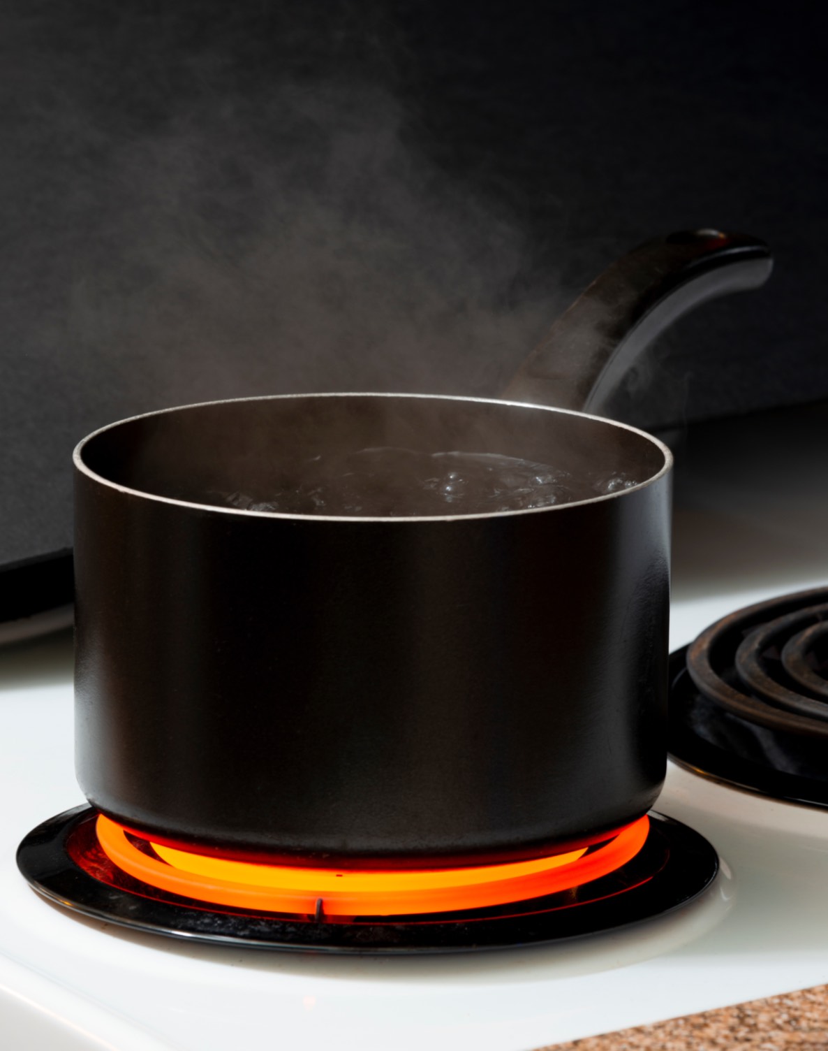A steaming pot on a hot electric stove coil thanks to tips from Custom Electrical.