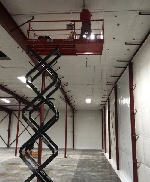 Custom Electrical industrial electrician using a lift - learn more about their responsibilities with our industrial electrician FAQ in Utah.